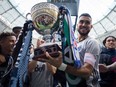 Vancouver Whitecaps' Pedro Morales, centre, hoists the Cascadia Cup as teammates Erik Hurtado, left, and Masato Kudo, right, watch after they defeated the Portland Timbers 4-1 during an MLS soccer game in Vancouver, B.C., on Sunday October 23, 2016. The trophy was created by fans of the Vancouver Whitecaps, Seattle Sounders and Portland Timbers and is awarded to the best soccer team in the Pacific Northwest each MLS season.