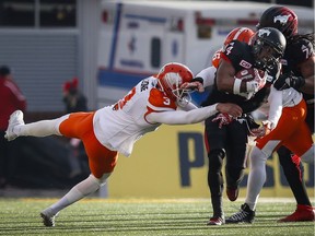 B.C. Lions punter Richie Leone, left, gets a hold of Calgary Stampeders' Roy Finch on Sunday. The Lions could have trouble keeping the CFL's best punter, who is about to become a free agent.