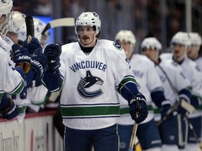 Vancouver Canucks players congratulate left wing Loui Eriksson (21) after his goal against the Colorado Avalanche during the first period Saturday's game in Denver.