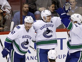Alex Burrows celebrates his goal with Baertschi and Horvat.