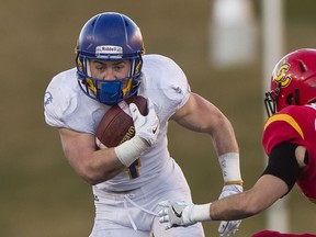 UBC Thunderbirds Ben Cummings (left) tries to break away from University of Calgary Dinos' Nathan Mitchell during U Sports Canada West Hardy Cup Championship football action at McMahon Stadium, Calgary. (Rich Lam/UBC Athletics Photo)