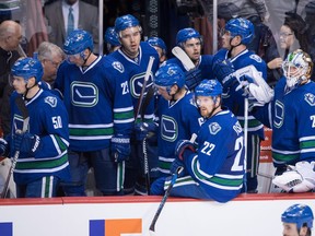 Vancouver Canucks' Daniel Sedin (22), of Sweden, goalie Jacob Markstrom (25), of Sweden, and their teammates watch from the bench after a Chicago Blackhawks goal was overturned on a review for being offside, during the overtime period of an NHL hockey game in Vancouver, B.C., on Saturday November 19, 2016.