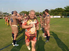Eddie Evans, in his clothing company's gear, walks off the field after a game at the Bankok 10s.