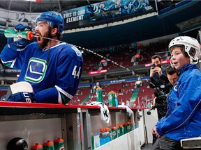 Erik Gudbranson of the Vancouver Canucks 'accidentally' squirts eight-year-old Toyota trainer Ben Purvis before their NHL game against the Buffalo Sabres on Oct. 20 at Rogers Arena.