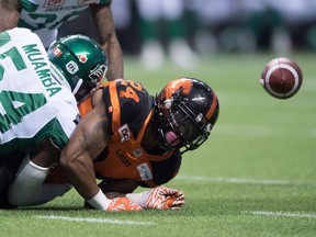 B.C. Lions' Jeremiah Johnson, right, fumbles the ball as he's hit by Saskatchewan Roughriders' Henoc Muamba on Saturday. Saskatchewan recovered the ball but lost 41-18.