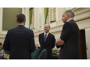 Canada Pension Plan Investment Board President and Chief Executive Officer Mark Machin speaks with Michel Leduc, left, and Edwin Cass, right, as they wait to appear at the Standing Committee on Finance on Parliament Hill, in Ottawa.