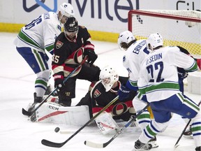 Ottawa Senators goalie Mike Condon (1) scrambles under pressure from Vancouver Canucks left wing Daniel Sedin (22), left wing Loui Eriksson (21) and right wing Jannik Hansen (36) in the final seconds of third period NHL action in Ottawa on Thursday, November 3, 2016.