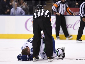 Referee Kelly Sutherland checks on Daniel Sedin.