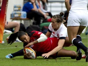 Canada's wing Magali Harvey (L) is tackled by England's centre Emily Scarratt during the IRB Women's Rugby World Cup final match between England and Canada at the Jean Bouin Stadium in Paris on August 17, 2014.