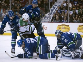 Vancouver Canucks left wing Loui Eriksson, Daniel Sedin and Erik Gudbranson stop Dallas Stars center Tyler Seguin from getting a shot on net.