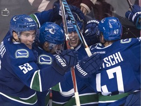 Vancouver Canucks defenceman Troy Stecher (51) celebrates his goal against the Dallas Stars with teammates Bo Horvat (53) Alexandre Burrows (14) and Sven Baertschi (47) during third period NHL action in Vancouver, B.C. Sunday, Nov. 13, 2016.