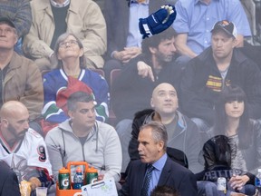 A glove is thrown above Vancouver Canucks head coach Willie Desjardins.