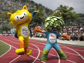 FILE - In this Nov. 24, 2014 file photo, the mascots of the Rio 2016 Olympics, left, and Paralympic Games make their first official appearance at a public school in the Santa Teresa neighborhood of Rio de Janeiro, Brazil. Almost four months after the Olympics ended, Rio de Janeiro organizers are struggling to pay their bills including $3.7 million owed to the International Paralympic Committee. (AP Photo/Felipe Dana, File)