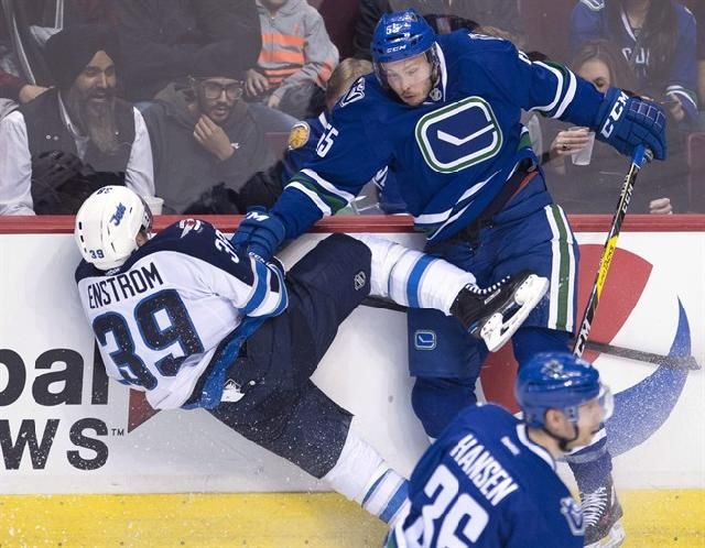 Vancouver Canucks defenceman Alex Biega (55) goes into the boards with Winnipeg Jets defenceman Toby Enstrom (39) during third period NHL action in Vancouver, B.C. Tuesday, Dec. 20, 2016. Thirty-three games into 2016-17, the Canucks are still looking for that elusive complete effort. THE CANADIAN PRESS/Jonathan Hayward