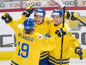 Sweden Jonathan Dahlen (27) celebrates with teammates Alexander Nylander (19) and Carl Grundstrom (16) after scoring his third goal during third period IIHF World Junior Championships hockey action against Czech Republic Saturday, December 31, 2016 in Montreal. THE CANADIAN PRESS/Ryan Remiorz