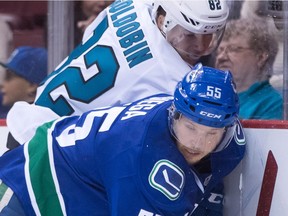 Vancouver Canucks' Alex Biega, front, and San Jose Sharks' Nikolay Goldobin, of Russia, battle for the puck during the first period of a pre-season NHL hockey game in Vancouver, B.C., on Sunday October 2, 2016.