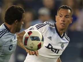 Vancouver Whitecaps forward Blas Perez (27) challenges Sporting Kansas City defender Kevin Ellis, left, during the first half of an MLS soccer match in Kansas City, Kan., Saturday, Aug. 20, 2016.