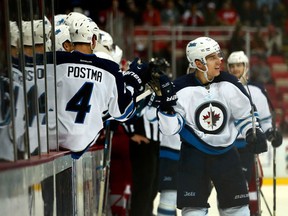 Brandon Tanev is congratulated by teammates at the Winnipeg Jets bench.