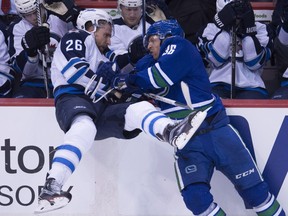 Jannik Hansen, left, and Henrik Sedin of the Vancouver Canucks react to a play Tuesday in their 4-1 win over the Winnipeg Jets.