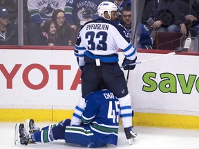 Jets defenceman Dustin Byfuglien fights for control of the puck with Michael Chaput.