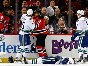 Taylor Hall of the New Jersey Devils and Michael Chaput of the Vancouver Canucks fight after Taylor Hall checked Philip Larsen.
