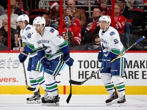 Brandon Sutter skates back to the bench with teammates Markus Granlund and Alex Biega after scoring in the third period.