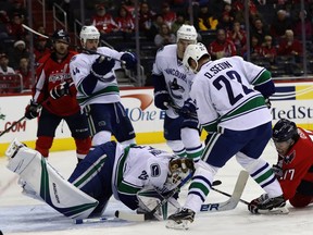 Jacob Markstrom and T.J. Oshie go after the puck.