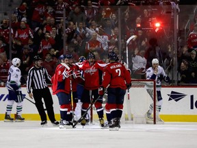 Alex Ovechkin of the Capitals (C) celebrates with Justin Williams (L) after Williams scored a thrid period goal against the Vancouver Canucks at Verizon Center on December 11, 2016 in Washington, DC.