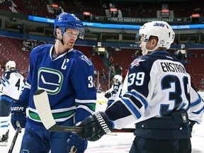 Swedes Henrik Sedin #33 of the Vancouver Canucks and Toby Enstrom #39 of the Winnipeg Jets chat before their NHL game at Rogers Arena December 20, 2016 in Vancouver, British Columbia, Canada.