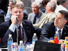 Mike Gillis and Laurence Gilman work the Canucks' table at the 2009 entry draft in Montreal.