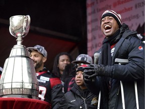 Ottawa Redblacks Henry Burris stands next to the Grey Cup as he speaks at rally at Aberdeen Square, celebrating the team's victory over the Calgary Stampeders, Tuesday, Nov. 29, 2016 in Ottawa.