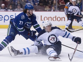 Canucks D-man Ben Hutton takes down Patrik Laine early in Tuesday night's 4-1 win over the Jets.