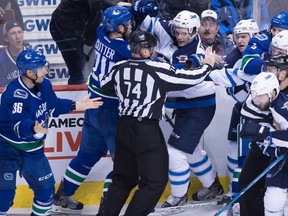 Vancouver Canucks' Jannik Hansen (36), of Denmark, Brandon Sutter (20) and Luca Sbisa, back right, of Italy, tangle with Winnipeg Jets' Jacob Trouba, centre, Bryan Little, Blake Wheeler, right, and Mathieu Perreault, front right, during the second period of an NHL hockey game in Vancouver, B.C., on Thursday December 22, 2016.