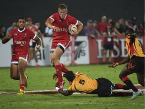 Canada's John Moonlight jumps with the ball over a tackle from Uganda's Michael Okorach in the 13th place match of the World Rugby Sevens Series. Uganda lost 17-20 to Canada in Dubai, the United Arab Emirates, Saturday, Dec. 3, 2016