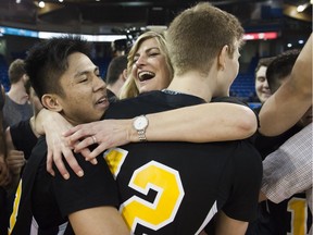 Ron Pettigrew co-coach Dianne Tower hugs Lance Gavino (left) and her son Garrett Tower after Lions defeated Credo Christian to win B.C. single-A boys high school basketball championship at the Langley Event Centre.