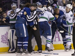 The Toronto Maple Leafs and Vancouver Canucks brawl during their Nov. 5 game in Toronto. The two teams play again Saturday night at Rogers Arena, starting at 4 p.m.
