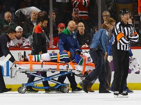 Philip Larsen of the Canucks is taken off the ice on a stretcher.