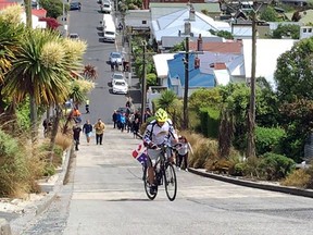 Cyclist Rudy Pospisil  climbing Baldwin Street in Dunedin, New Zealand, the steepest street in the world.