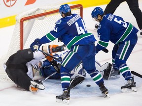 The Ducks' Ryan Kesler, left, is checked to the ice by the Canucks' Erik Gudbranson.