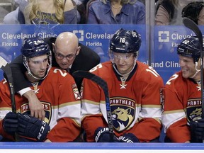 Florida Panthers interim head coach Tom Rowe, center, talks to Seth Griffith (24) in the first period of an NHL hockey game against the Vancouver Canucks, Saturday, Dec. 10, 2016, in Sunrise, Fla. The Panthers won 4-2.