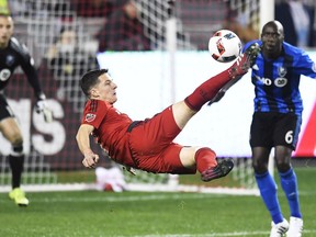 Toronto FC forward Will Johnson (7) takes a shot on Montreal Impact goalkeeper Evan Bush (1) as Impact defender Hassoun Camara (6) looks on during first half MLS Eastern Conference playoff soccer final action in Toronto on Wednesday, November 30, 2016.