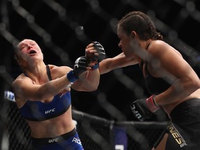 Amanda Nunes of Brazil, right, punches Ronda Rousey in their UFC women's bantamweight championship bout during the UFC 207 event on December 30, 2016 in Las Vegas, Nevada.