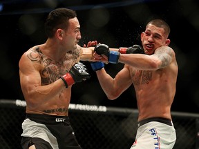 Max Holloway, left, connects to the face of Anthony Pettis in an interim featherweight title bout during the main event of UFC 206 at the Air Canada Centre in Toronto.