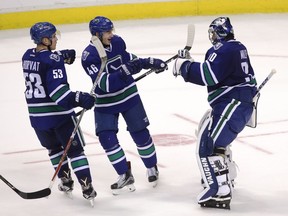Vancouver Canucks goaltender Ryan Miller (30) celebrates his team's win with teammates Bo Horvat (53) and Jayson Megna (46) following shootout NHL hockey action against the Toronto Maple Leafs on Saturday.