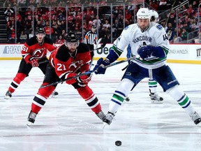 Kyle Palmieri and Erik Gudbranson fight for the puck in the second period on December 6, 2016 at Prudential Center in Newark, New Jersey.