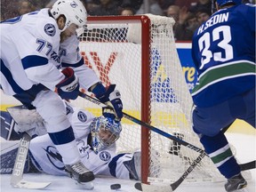 Vancouver Canucks #33 Henrik Sedin is unable to tap in a puck past Tampa Bay Lightning #77 Victor Hedman as Tampa Bay Lightning goalie Andrei Vasilevskly sprawls on the ice  in the first period of a regular season NHL hockey game at Rogers Arena, Vancouver, December 16 2016.