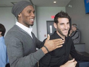 Montreal Impact striker Didier Drogba, left, has a laugh with teammate Ignacio Piatti as he says goodbye after the end of season news conference Friday, December 2, 2016 in Montreal. The departure of Drogba, who had become a bench player, was the only major change as the Montreal Impact opened camp at Olympic Stadium. THE CANADIAN PRESS/Ryan Remiorz