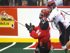 Calgary Roughnecks Tyson Bell (94) is grabbed by Stealth Ryan Wagner during National Lacross League game action between the Vancouver Stealth and the Calgary Roughnecks at the Scotiabank Saddledome in Calgary on Friday January 6, 2017.