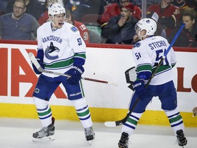 Canucks centre Bo Horvat, left, celebrates his goal with teammate Troy Stecher during Vancouver's 3-1 loss in in Calgary on Saturday.