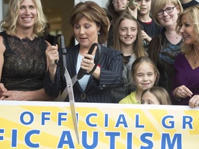 Premier Christy Clark uses a giant pair of scissors to cut a ribbon at the new facility for the Pacific Autism Family Network in Richmond late last year.